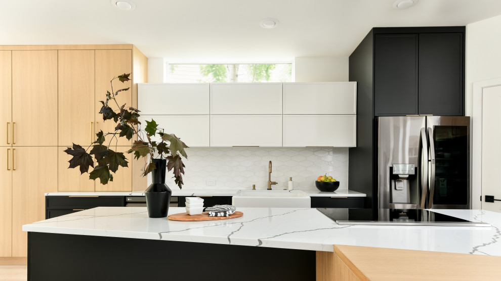Design ideas for a large contemporary single-wall eat-in kitchen in Seattle with a farmhouse sink, shaker cabinets, black cabinets, quartz benchtops, white splashback, porcelain splashback, stainless steel appliances, medium hardwood floors, with island, yellow floor and white benchtop.