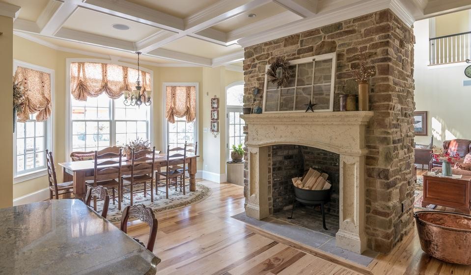 Country kitchen/dining combo in Toronto with a stone fireplace surround.