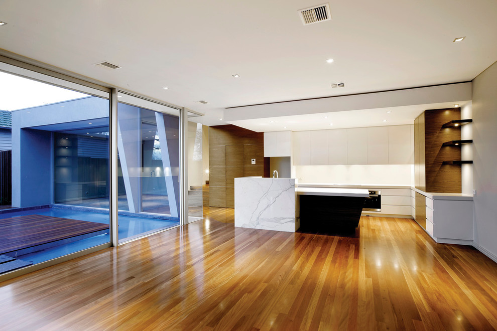 Photo of a contemporary open plan kitchen in Melbourne with an undermount sink, medium wood cabinets, white splashback and stainless steel appliances.