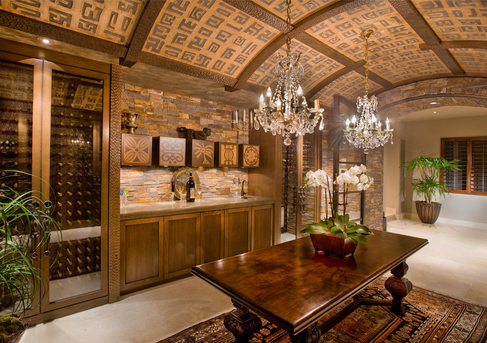 Inspiration for an expansive mediterranean wine cellar in Orange County with limestone floors, display racks and beige floor.