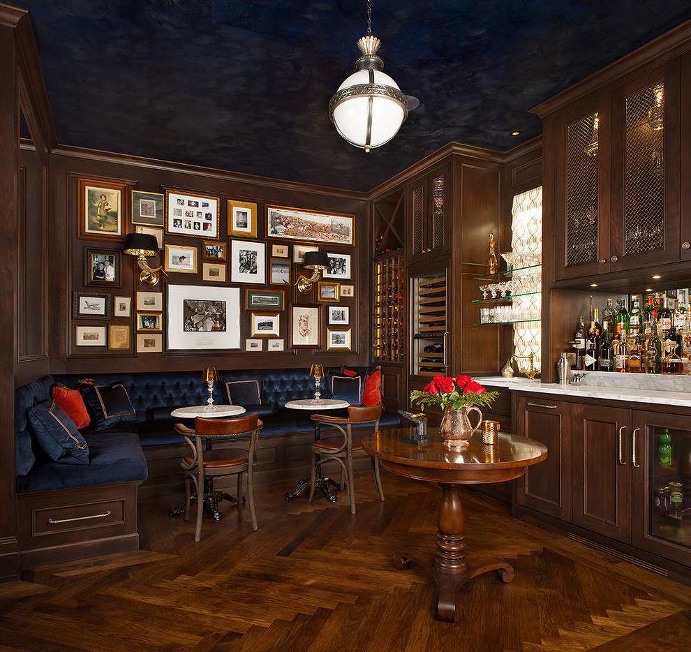 Inspiration for an expansive traditional single-wall seated home bar in Grand Rapids with recessed-panel cabinets, dark wood cabinets, medium hardwood floors, an undermount sink, marble benchtops, multi-coloured benchtop and brown floor.
