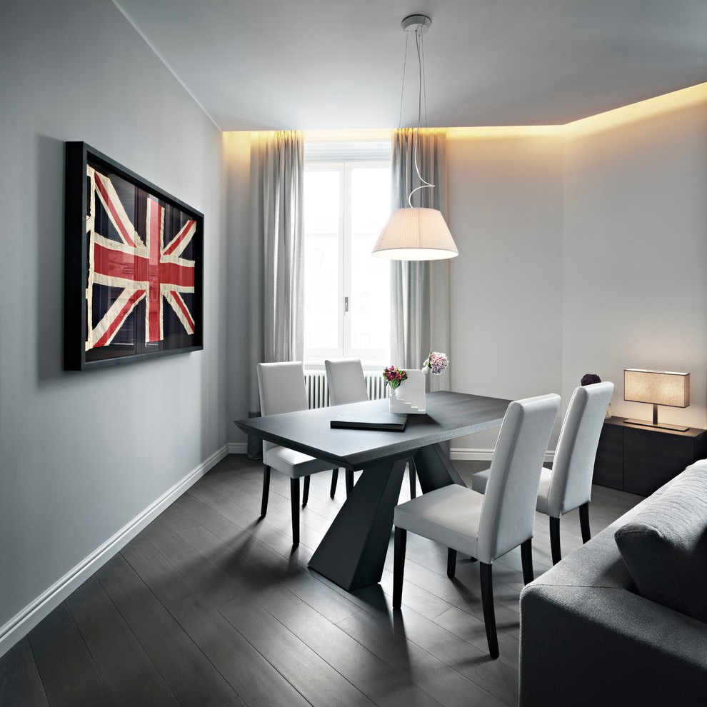 This is an example of a mid-sized contemporary open plan dining in Milan with white walls and dark hardwood floors.