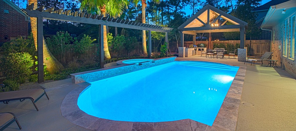 Photo of a mid-sized transitional backyard custom-shaped pool in Houston with natural stone pavers.