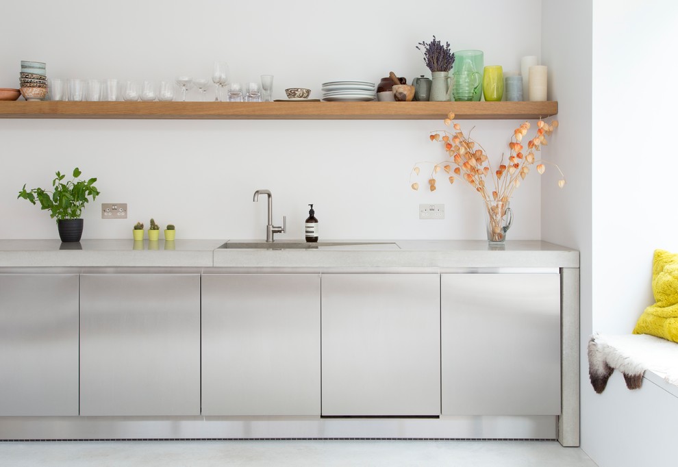 Design ideas for a mid-sized contemporary single-wall eat-in kitchen in London with an integrated sink, flat-panel cabinets, stainless steel cabinets, concrete benchtops, stainless steel appliances, no island, white splashback, grey floor and grey benchtop.