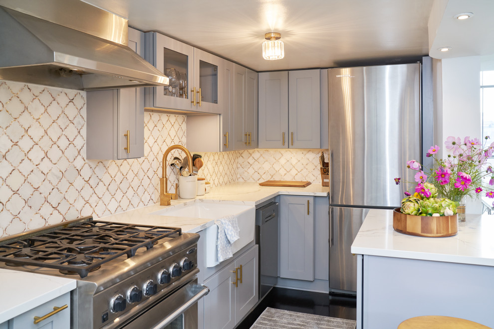 ニューヨークにある高級な小さなトラディショナルスタイルのおしゃれなキッチン (エプロンフロントシンク、フラットパネル扉のキャビネット、グレーのキャビネット、クオーツストーンカウンター、白いキッチンパネル、大理石のキッチンパネル、シルバーの調理設備、濃色無垢フローリング、茶色い床、白いキッチンカウンター) の写真
