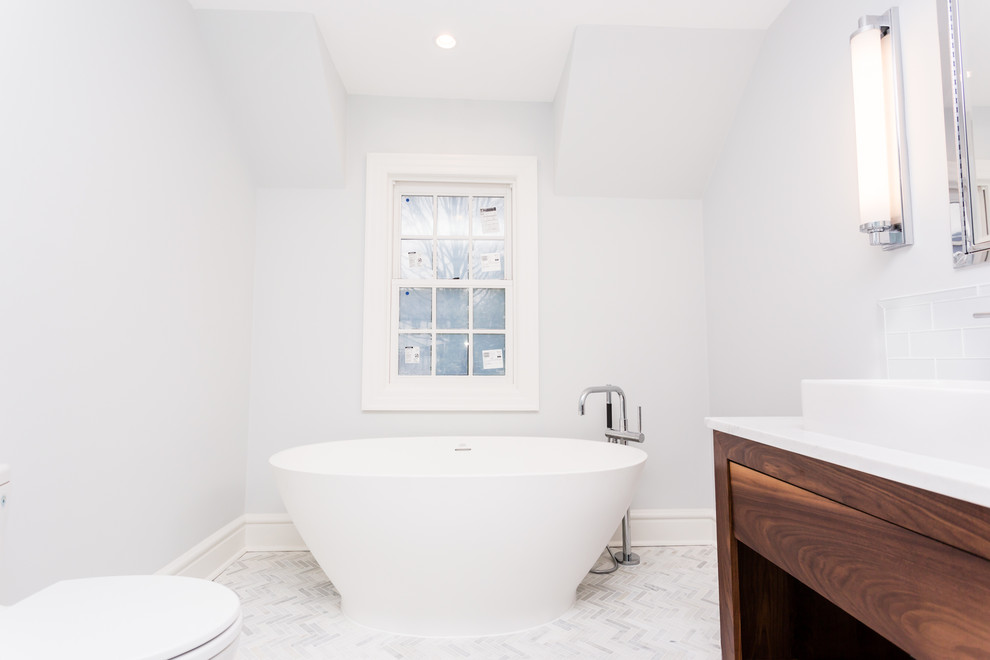 Photo of a contemporary master bathroom in St Louis with open cabinets, medium wood cabinets, a freestanding tub, white tile, subway tile, grey walls, mosaic tile floors, a vessel sink and marble benchtops.