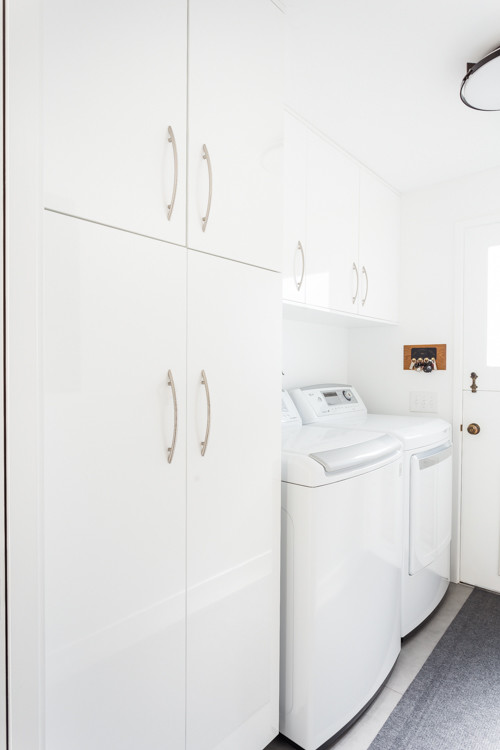 Photo of a contemporary u-shaped laundry room in San Francisco with an undermount sink, flat-panel cabinets and white cabinets.