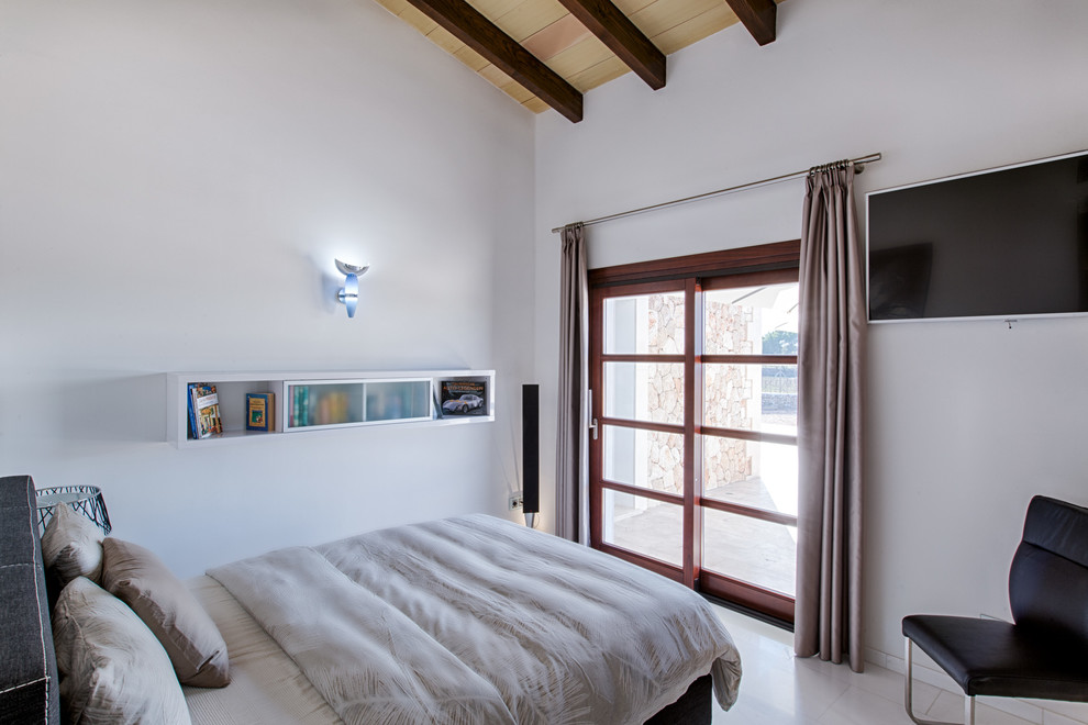 Photo of a mid-sized country master bedroom in Palma de Mallorca with white walls and no fireplace.