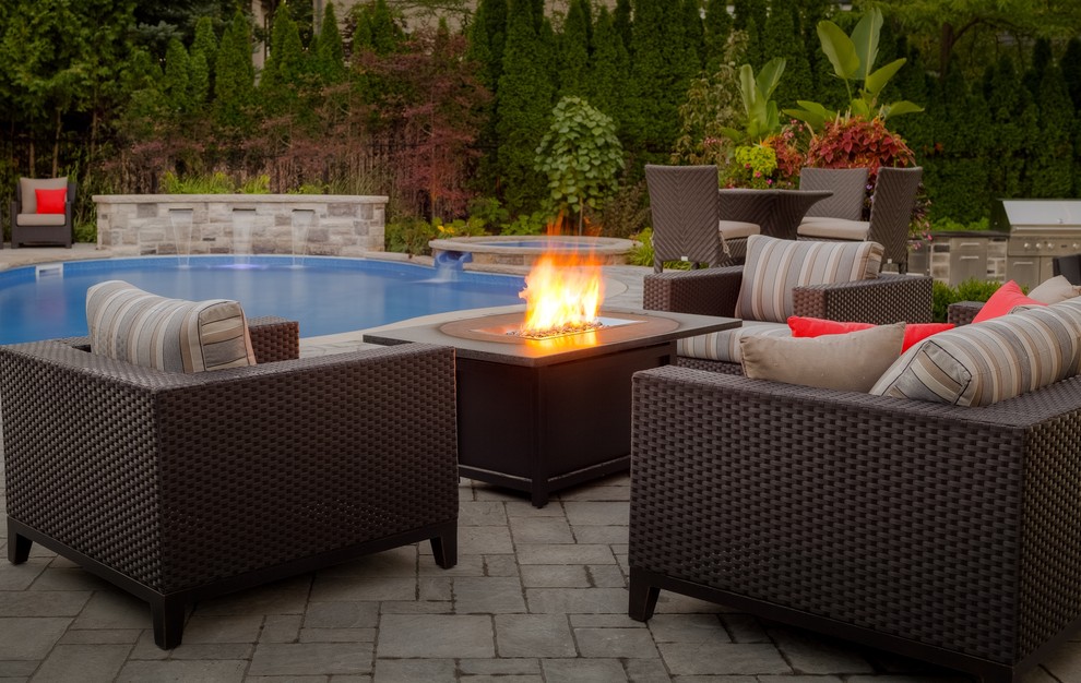 Photo of a large transitional full sun backyard concrete paver landscaping in Toronto with a fire pit for summer.
