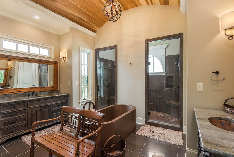 Inspiration for a large traditional master bathroom in Other with an undermount sink, raised-panel cabinets, dark wood cabinets, granite benchtops, a freestanding tub, a double shower, brown tile, ceramic tile, beige walls and grey benchtops.