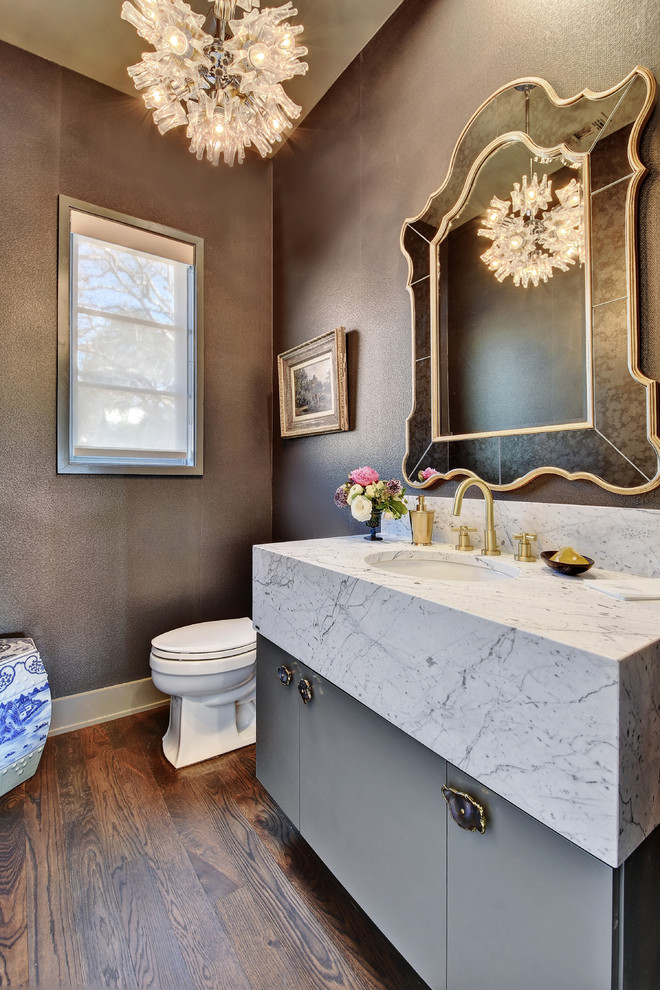 Design ideas for a transitional powder room in Austin with flat-panel cabinets, grey cabinets, brown walls, medium hardwood floors, an undermount sink and white benchtops.
