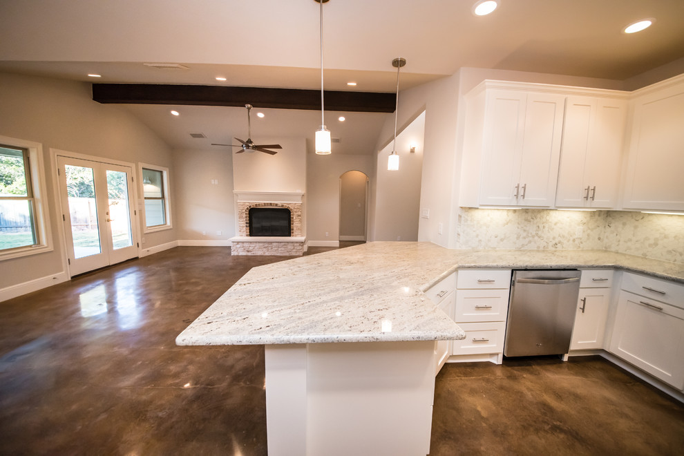 This is an example of a mid-sized arts and crafts u-shaped open plan kitchen in Austin with concrete floors, a double-bowl sink, shaker cabinets, white cabinets, granite benchtops, beige splashback, ceramic splashback, stainless steel appliances and a peninsula.