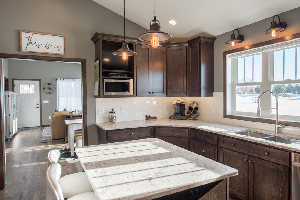 Enclosed kitchen - large rustic u-shaped dark wood floor and brown floor enclosed kitchen idea in Minneapolis with a double-bowl sink, shaker cabinets, dark wood cabinets, granite countertops, white backsplash, subway tile backsplash, stainless steel appliances and an island