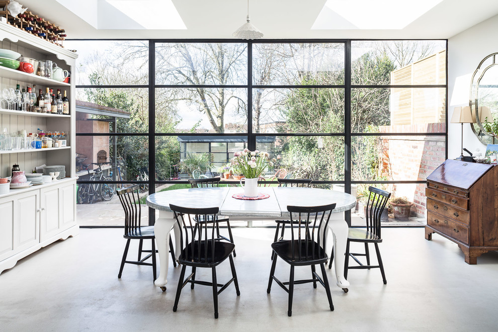 Design ideas for a large contemporary separate dining room in London with white walls, concrete floors and grey floor.