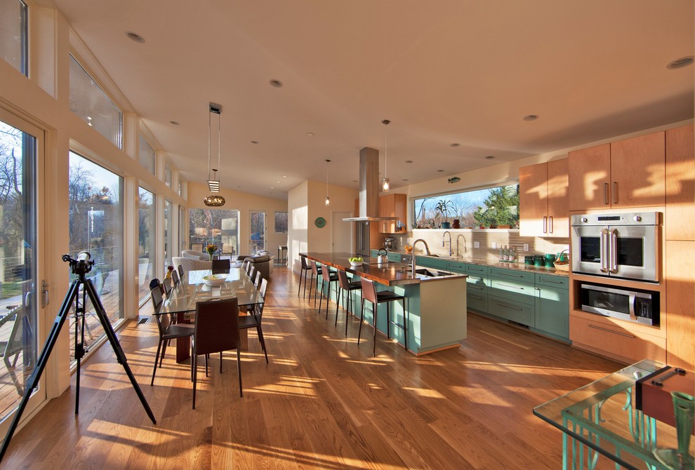 Inspiration for a large contemporary single-wall eat-in kitchen in DC Metro with an undermount sink, flat-panel cabinets, turquoise cabinets, wood benchtops, beige splashback, stainless steel appliances, medium hardwood floors, with island, beige floor and beige benchtop.
