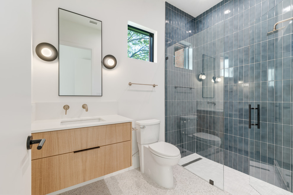 Inspiration for a midcentury kids bathroom in Dallas with flat-panel cabinets, brown cabinets, a curbless shower, a two-piece toilet, blue tile, ceramic tile, white walls, terrazzo floors, an undermount sink, engineered quartz benchtops, grey floor, a hinged shower door, white benchtops, a single vanity and a floating vanity.