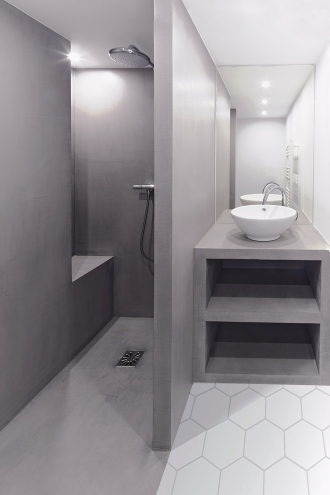 This is an example of a contemporary bathroom in Paris with a curbless shower, a wall-mount toilet, grey walls, concrete floors, a drop-in sink, grey floor and an open shower.