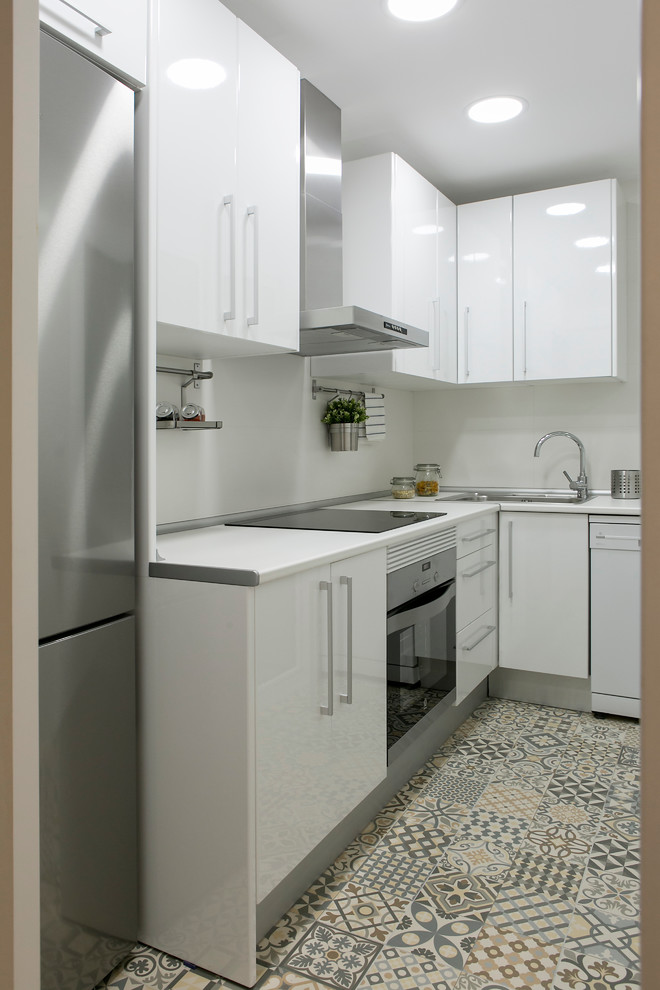 Small contemporary l-shaped separate kitchen in Barcelona with a single-bowl sink, flat-panel cabinets, white cabinets, white splashback, ceramic floors and no island.