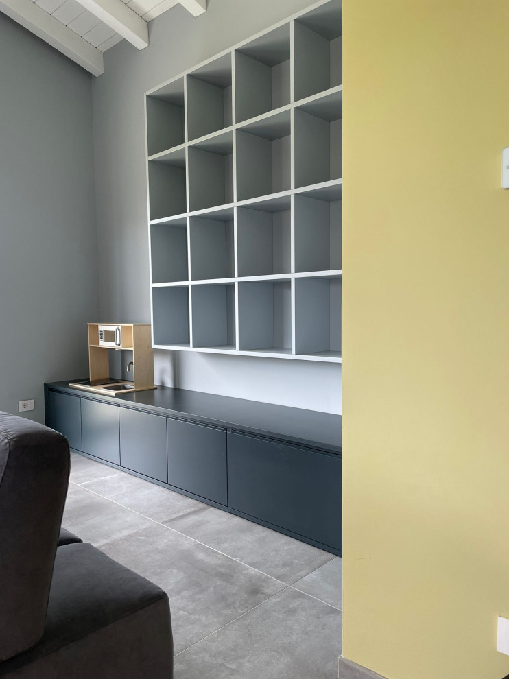Свежая идея для дизайна: маленькая гостиная комната в стиле модернизм с с книжными шкафами и полками, синими стенами и серым полом для на участке и в саду - отличное фото интерьера