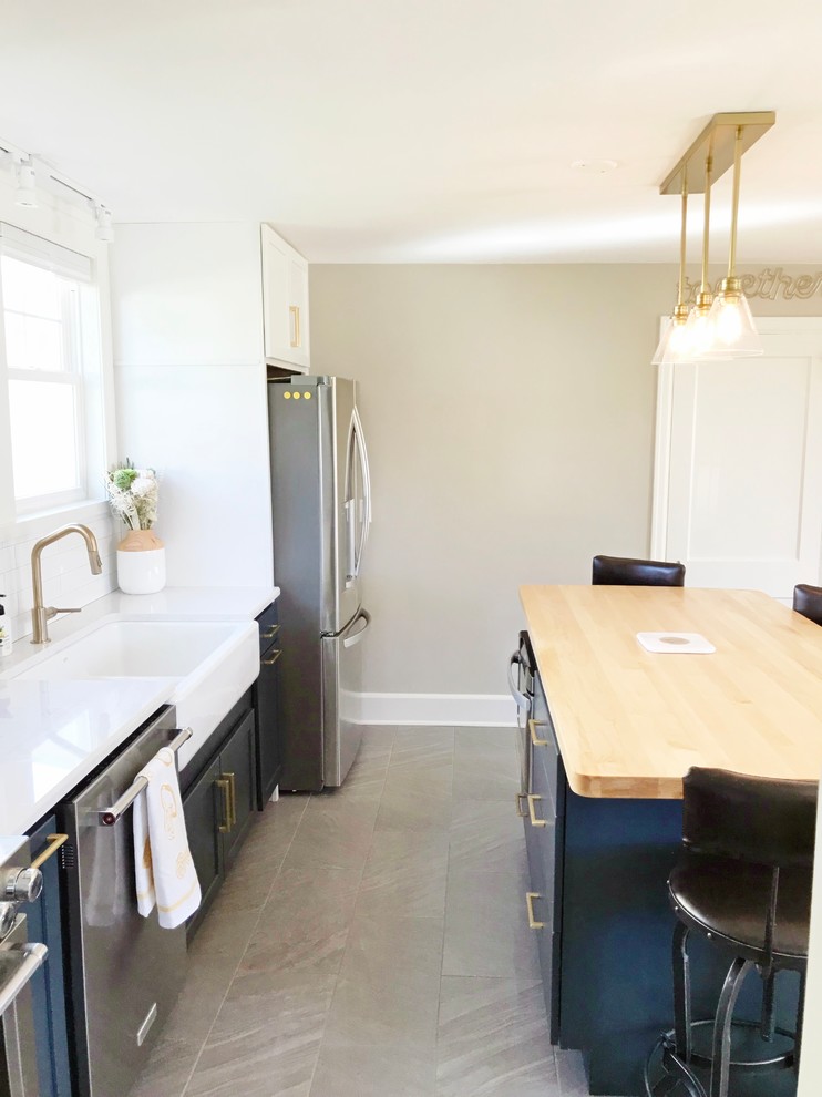 Inspiration for a transitional gray floor kitchen remodel with a farmhouse sink, quartz countertops and stainless steel appliances