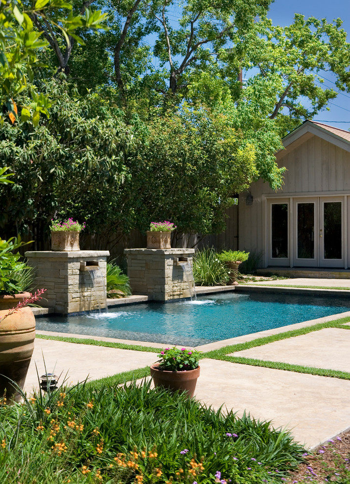 Design ideas for a mid-sized traditional backyard rectangular natural pool in Austin with a water feature and natural stone pavers.