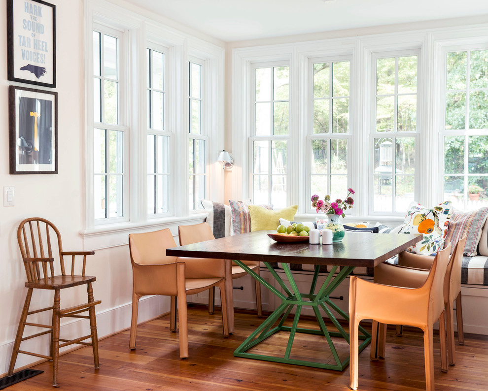 Example of a country medium tone wood floor dining room design in Raleigh with beige walls