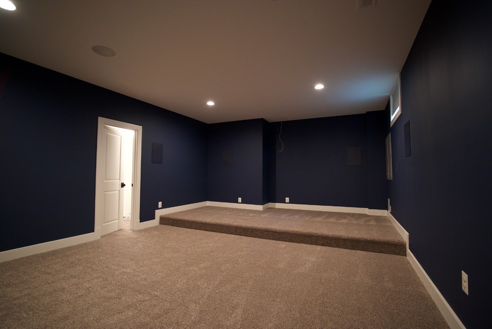 This is an example of an enclosed home theatre in DC Metro with blue walls, carpet and grey floor.