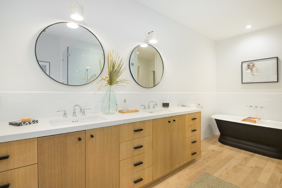 Design ideas for a mid-sized contemporary master bathroom in Los Angeles with medium wood cabinets, a freestanding tub, a one-piece toilet, white tile, subway tile, white walls, an undermount sink, engineered quartz benchtops, white benchtops, flat-panel cabinets, light hardwood floors and beige floor.