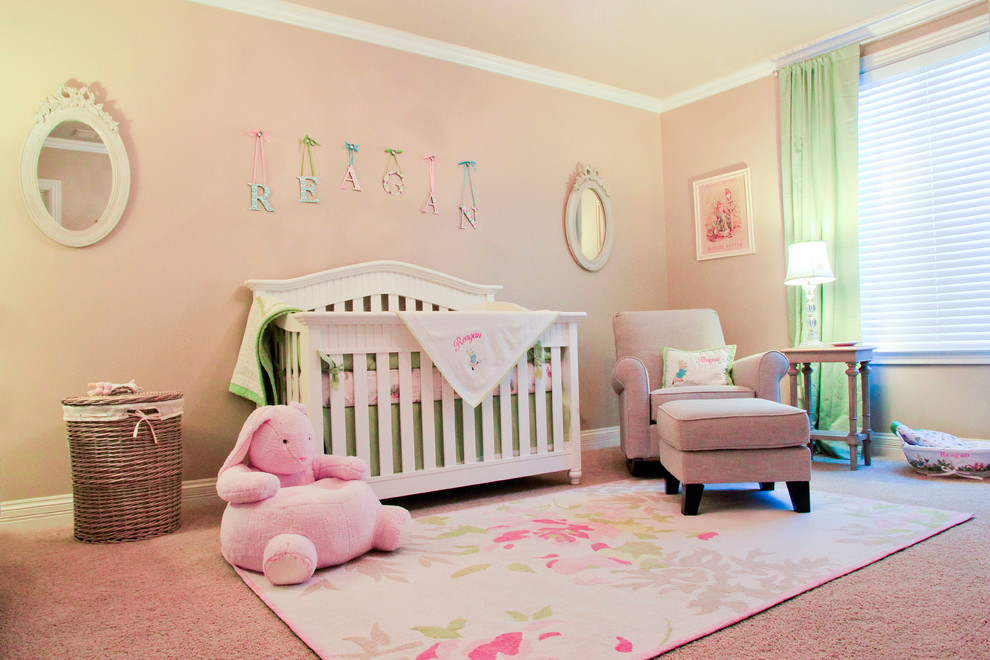 Traditional nursery in Louisville with pink walls and carpet for girls.