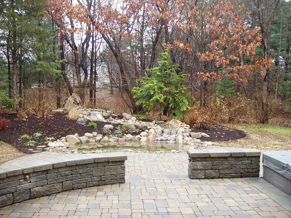 This is an example of a mid-sized arts and crafts backyard full sun formal garden for fall in Bridgeport with with pond and concrete pavers.