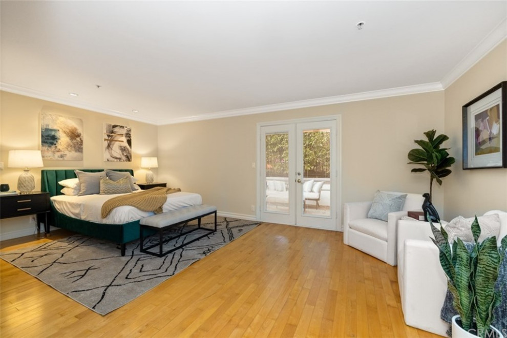 Ejemplo de habitación de invitados minimalista de tamaño medio con paredes beige, suelo marrón, suelo de madera clara y bandeja