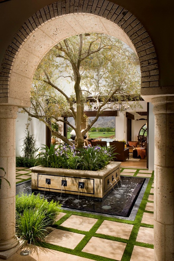 Inspiration for a mediterranean courtyard patio in Orange County with a water feature.