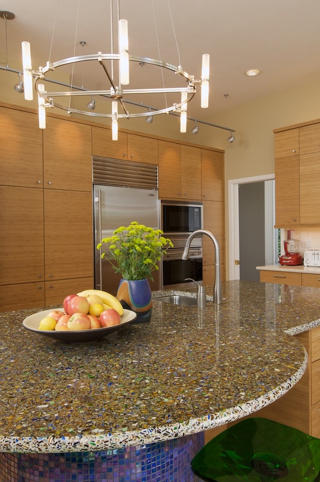 Design ideas for a contemporary kitchen in Seattle with recycled glass benchtops, an undermount sink, flat-panel cabinets, medium wood cabinets and stainless steel appliances.