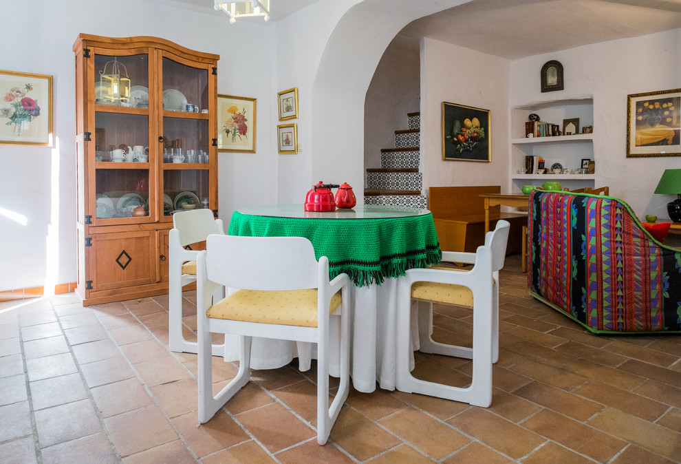 Mid-sized mediterranean separate dining room in Malaga with white walls, terra-cotta floors and no fireplace.
