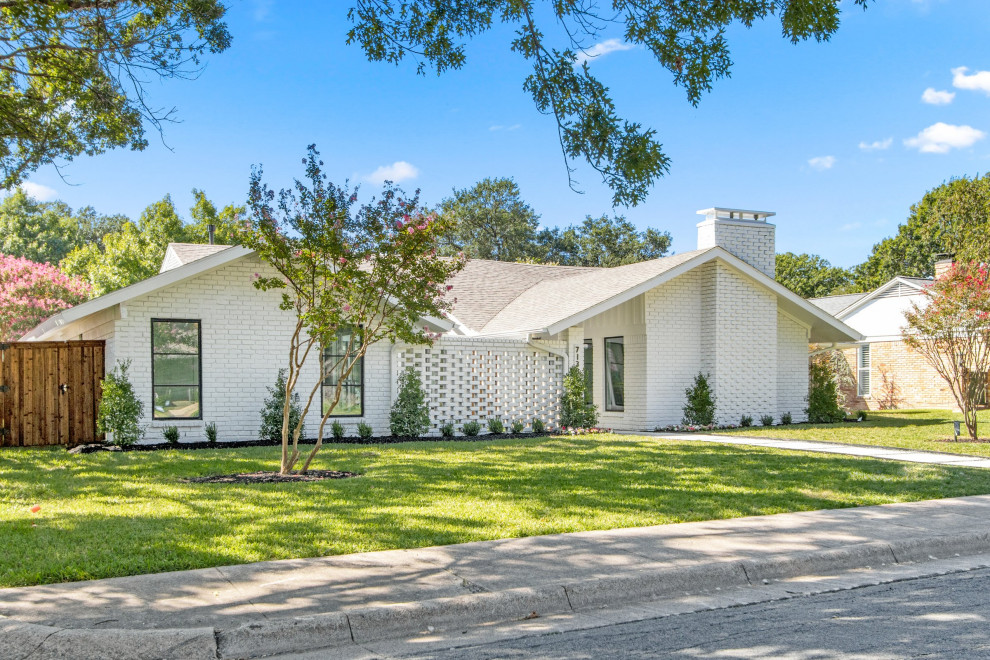 Expansive and white midcentury bungalow brick detached house in Dallas with a black roof.