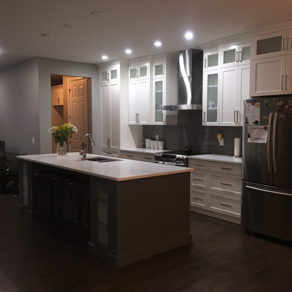Mid-sized single-wall dark wood floor eat-in kitchen photo in Calgary with an undermount sink, shaker cabinets, white cabinets, quartzite countertops, gray backsplash, subway tile backsplash, stainless steel appliances and an island