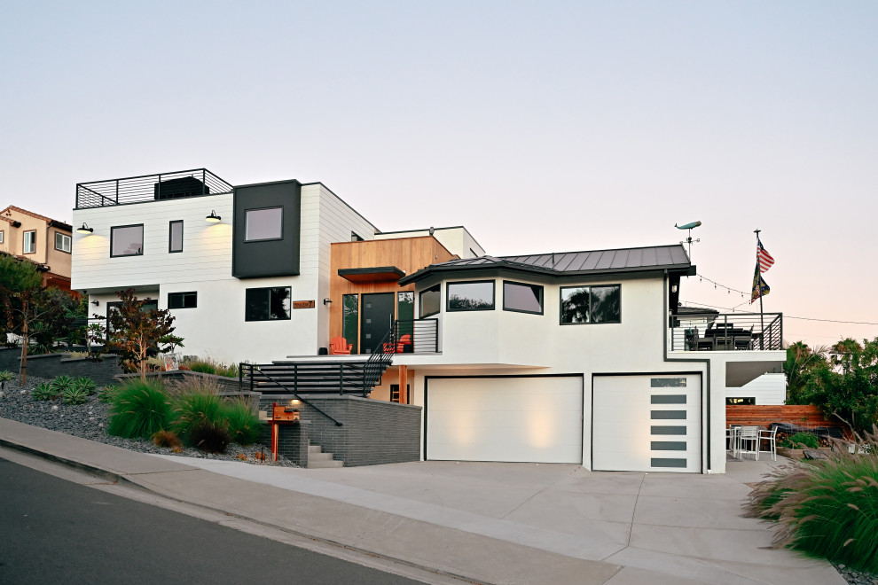 Design ideas for a mid-sized contemporary split-level stucco white house exterior in Orange County with a gable roof, a metal roof and a grey roof.