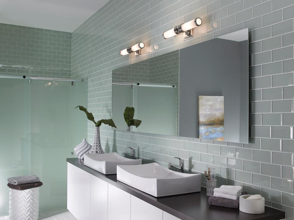 Mid-sized industrial bathroom in New York with a vessel sink, flat-panel cabinets, white cabinets, granite benchtops, a freestanding tub, a one-piece toilet, gray tile, subway tile, grey walls and ceramic floors.