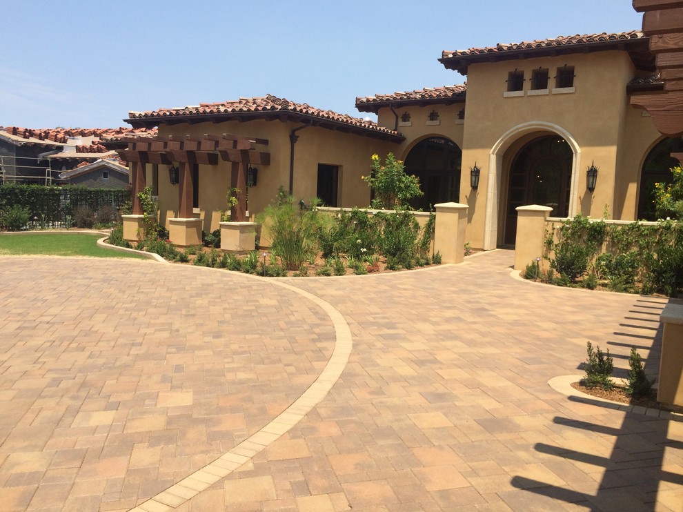 Traditional front yard driveway in San Diego with a garden path and concrete pavers.
