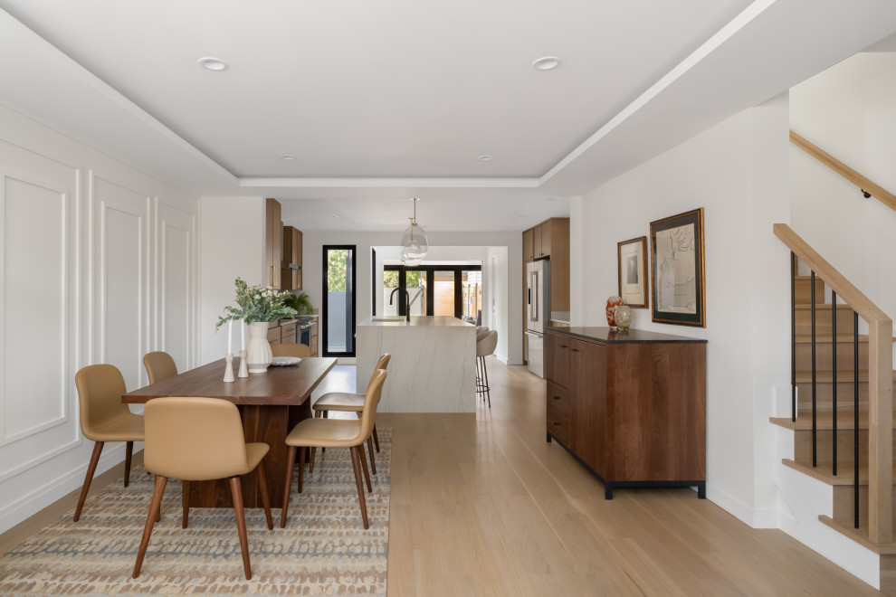 Example of a mid-sized trendy light wood floor, brown floor and wall paneling kitchen/dining room combo design in DC Metro with yellow walls