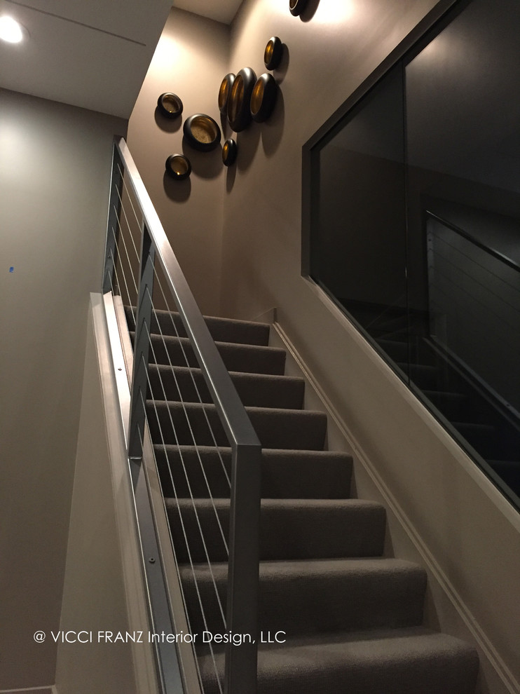 Cette image montre un grand escalier droit design avec des marches en moquette, des contremarches en moquette et un garde-corps en câble.