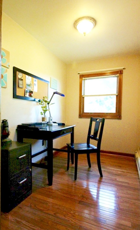 Design ideas for a mid-sized eclectic home office in New York with yellow walls, medium hardwood floors and a freestanding desk.
