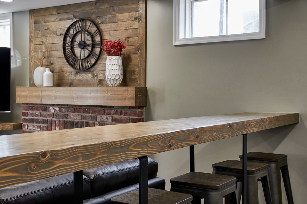 Large mountain style walk-out vinyl floor and brown floor basement photo in St Louis with gray walls and a standard fireplace
