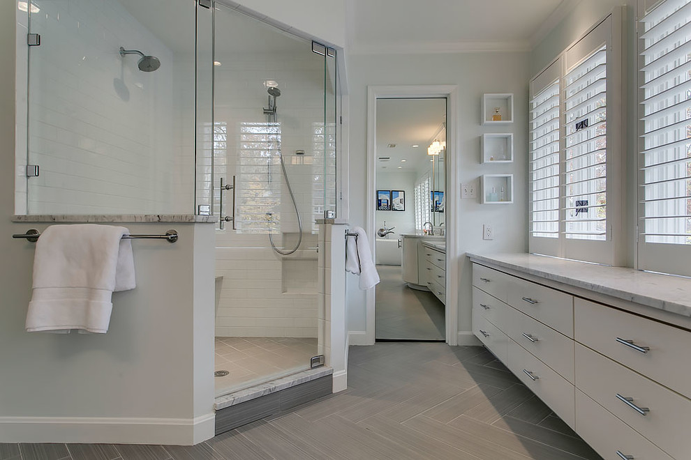 Example of a transitional gray tile ceramic tile freestanding bathtub design in Raleigh with flat-panel cabinets, white cabinets, an undermount sink and marble countertops