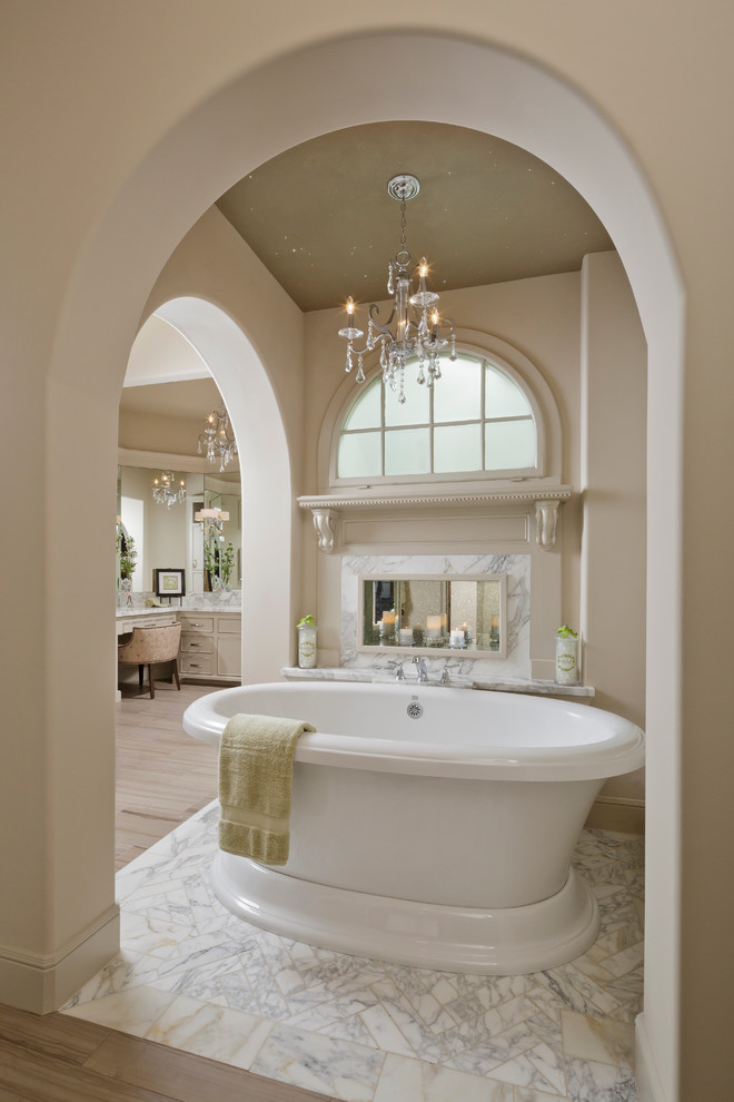 Photo of a large traditional master bathroom in Houston with a freestanding tub, a two-piece toilet and marble floors.