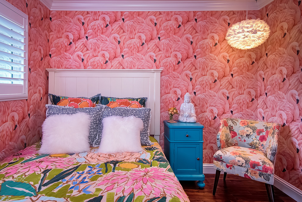 Inspiration for a small tropical guest bedroom in San Diego with pink walls and medium hardwood floors.