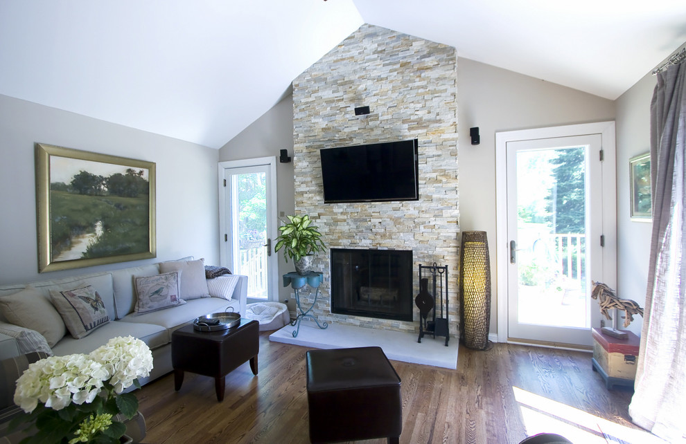 Inspiration for a mid-sized transitional open concept family room in Chicago with beige walls, light hardwood floors, a standard fireplace and a stone fireplace surround.