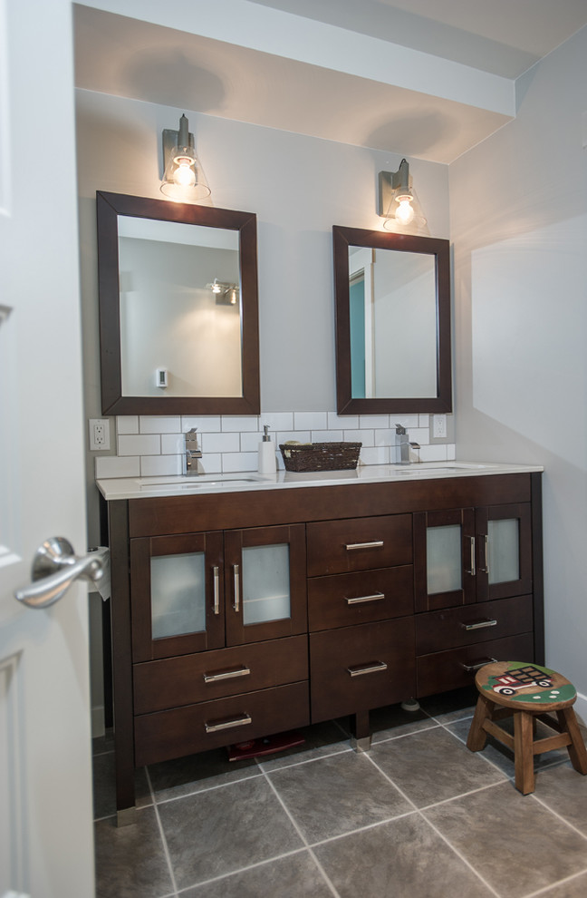 This is an example of a mid-sized contemporary master bathroom in Other with glass-front cabinets, medium wood cabinets, a one-piece toilet, gray tile, ceramic tile, grey walls, ceramic floors and an undermount sink.