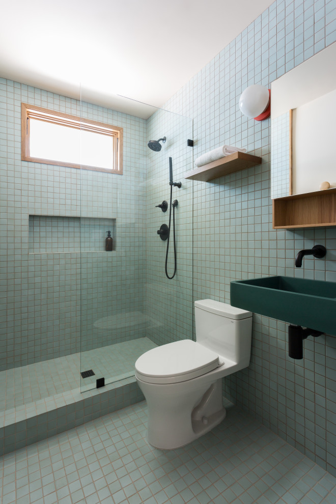 ロサンゼルスにある高級な小さなミッドセンチュリースタイルのおしゃれなバスルーム (浴槽なし) (緑のキャビネット、オープン型シャワー、一体型トイレ	、青いタイル、セラミックタイル、セラミックタイルの床、壁付け型シンク、青い床、オープンシャワー、洗面台1つ、フローティング洗面台) の写真