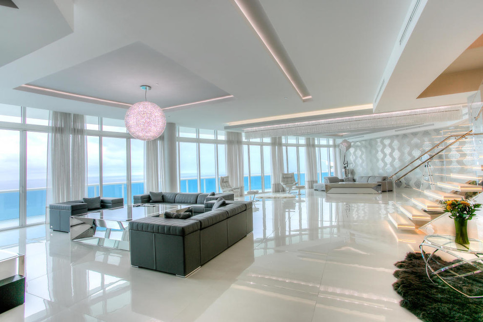 This is an example of a large modern formal open concept living room in Miami with porcelain floors, a wall-mounted tv, white walls and no fireplace.